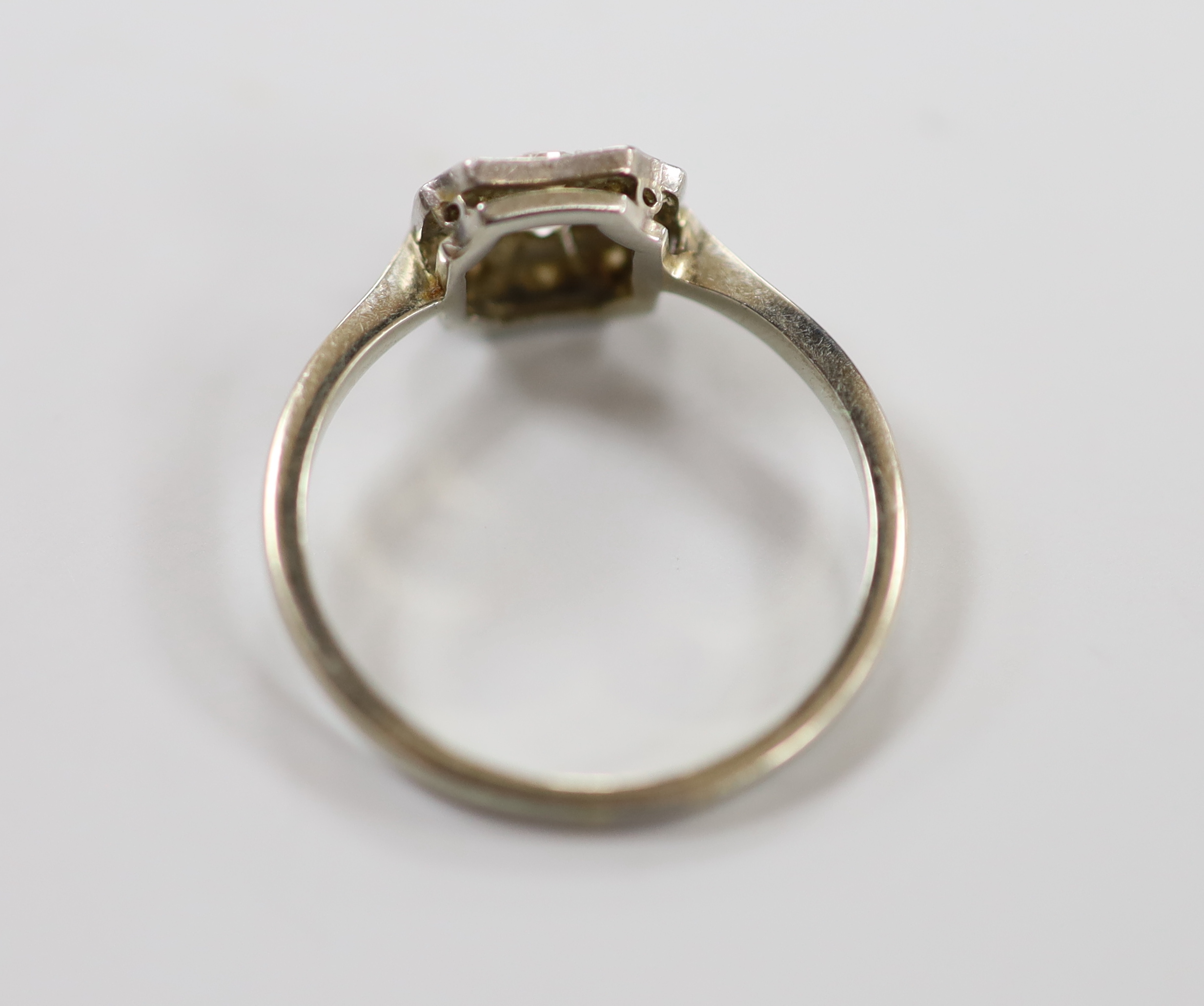 A 1920's white metal (stamped Pt) and nine stone diamond set cluster ring, size O, gross weight 2.4 grams.